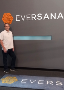 Man standing in front of EVERSANA sign at specialty pharmacy location