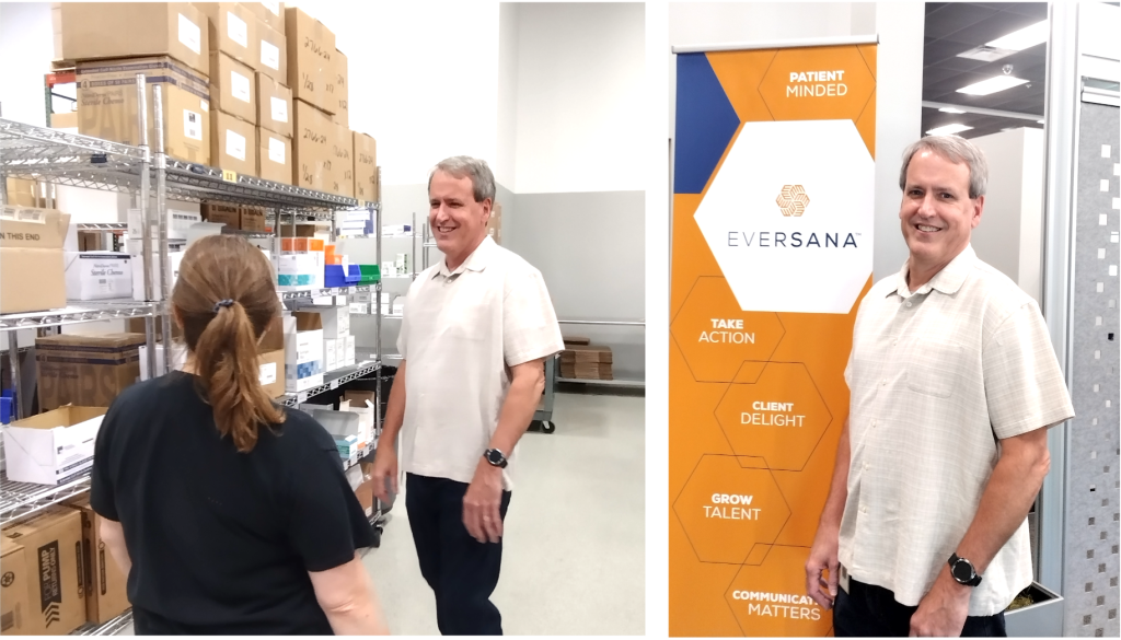 Man standing in specialty pharmacy warehouse and next to sign